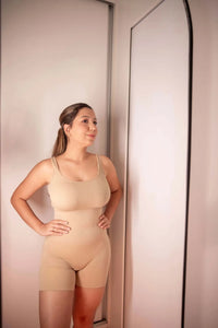 Macacão listrado bege com alças finas e shorts curtos.